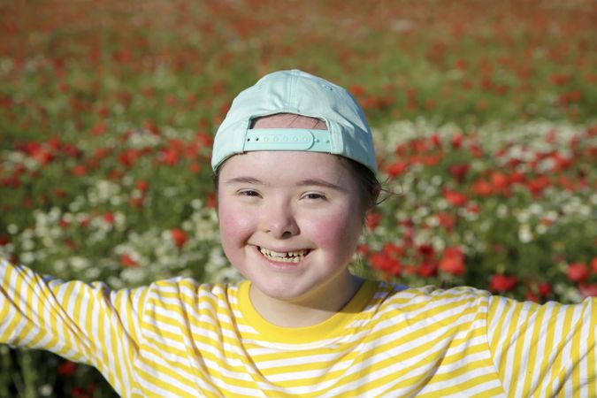 Happy young girl standing in front of flower field