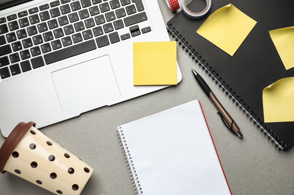 Laptop, Notebook and Plastic Coffee Cup on Table, Top View