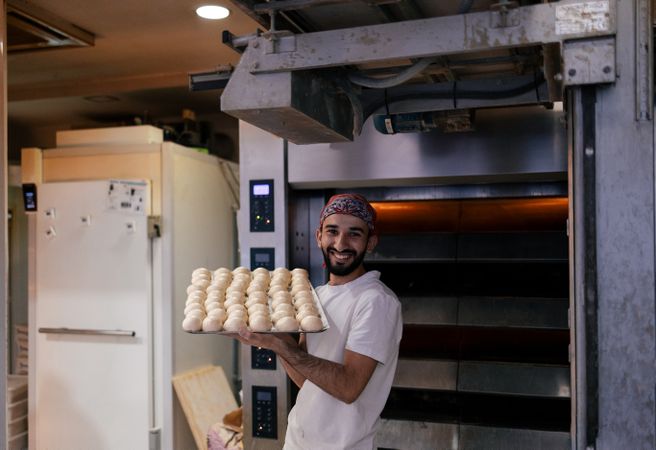 Arabic baker with tray with dough balls