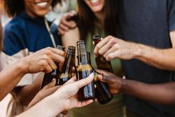 Hands of friends cheering with their beer bottles