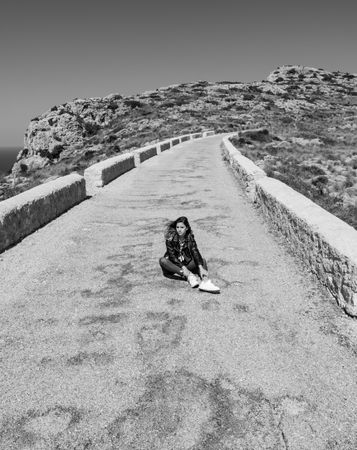 Woman sitting on stony path in countryside