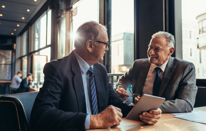 Two mature businessmen having an informal meeting at cafe