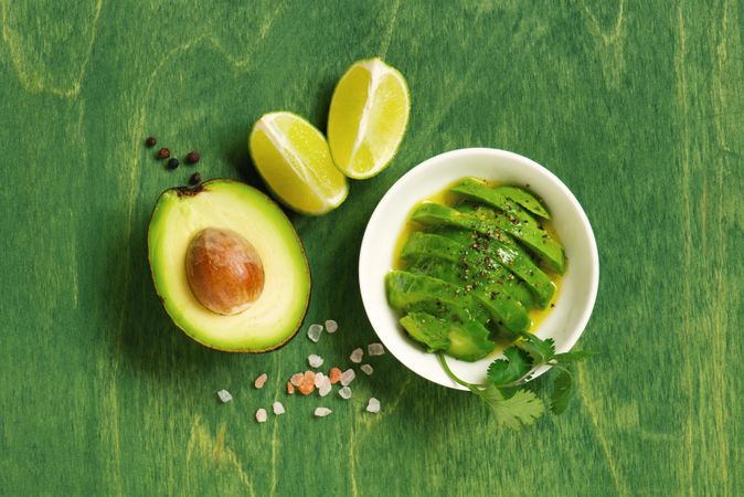 Avocado and lime on green table