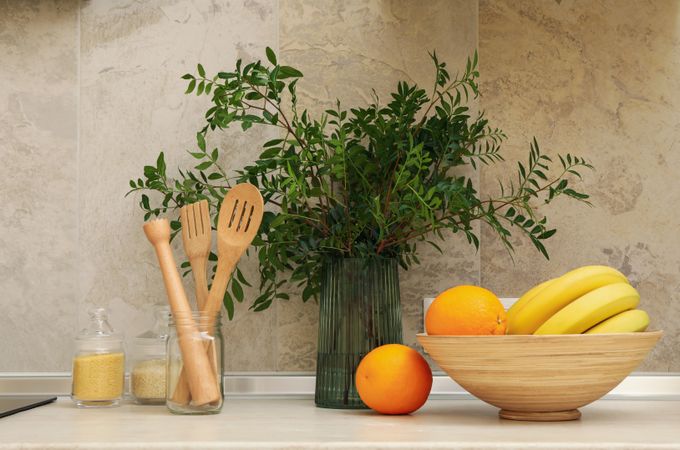 Kitchen interior with supplies, fruits and plant