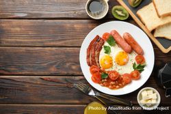 Top view of fried eggs, breakfast with kiwi, coffee and juice on table, copy space 4NX9D0