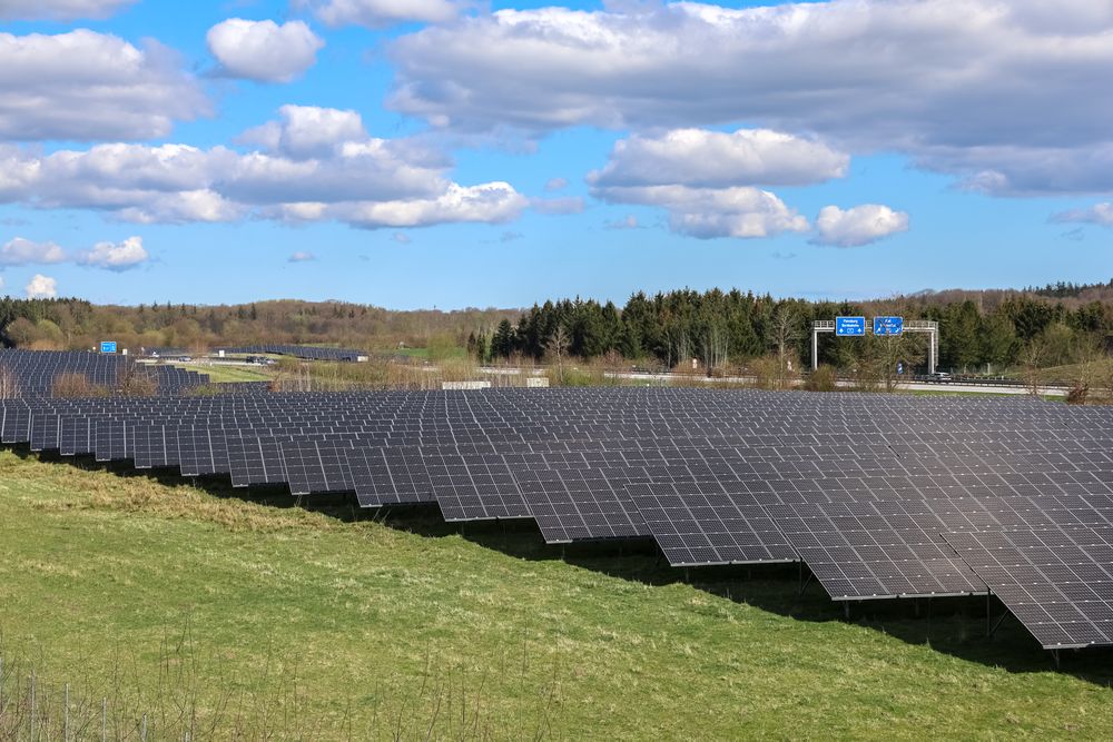 Photovoltaic plant providing clean energy near highway under cloudy sky