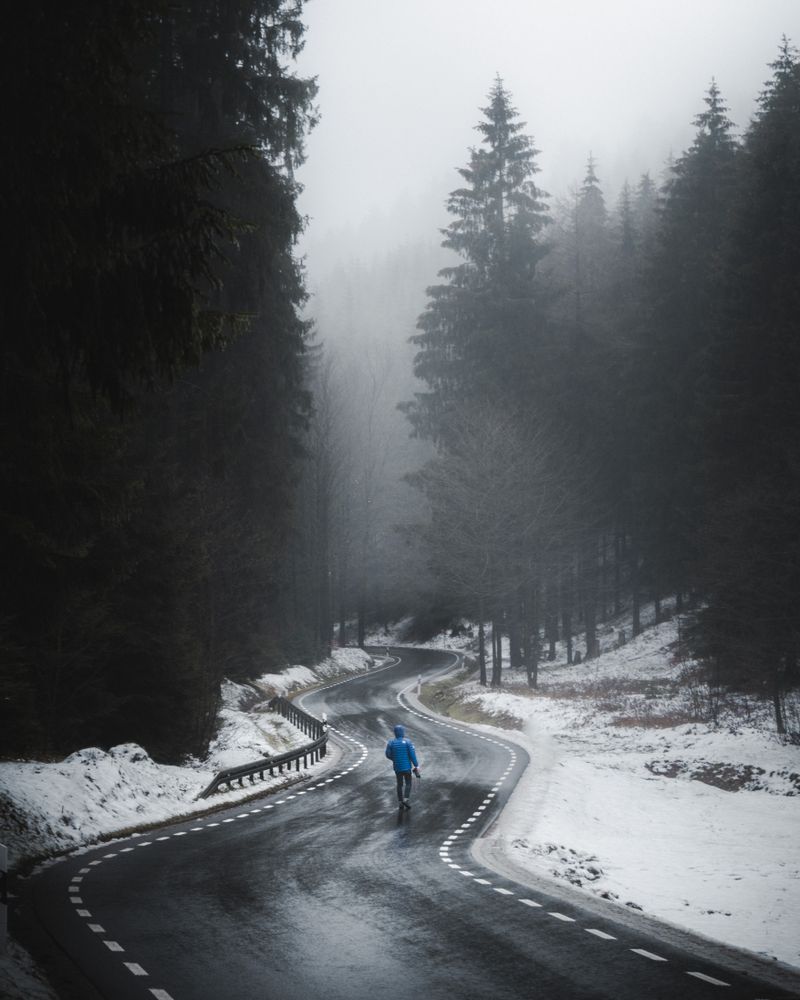 Person walking on empty snow covered ground