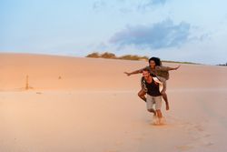 Couple piggybacking and having fun at beach