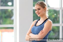 Blonde woman with arms crossed in bright room 5l6RYb