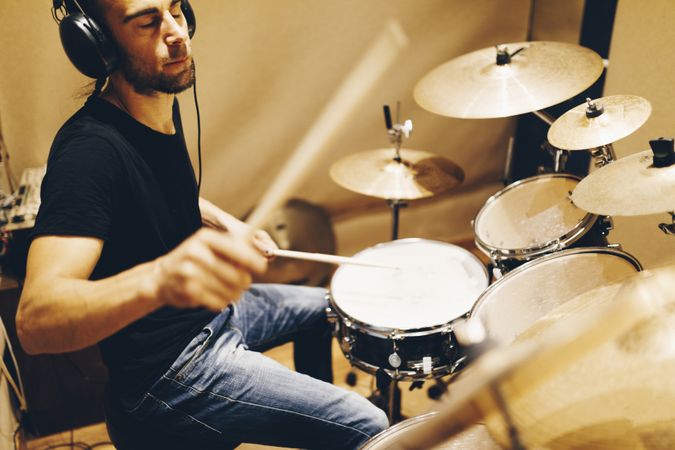 Man with headphones playing on drums