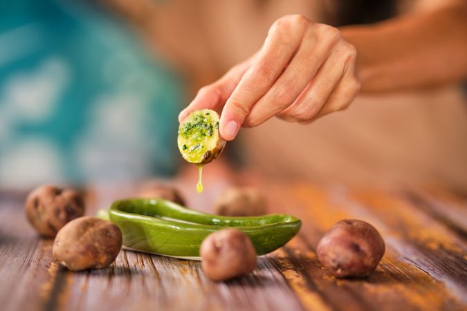 Crop woman dipping potato into sauce