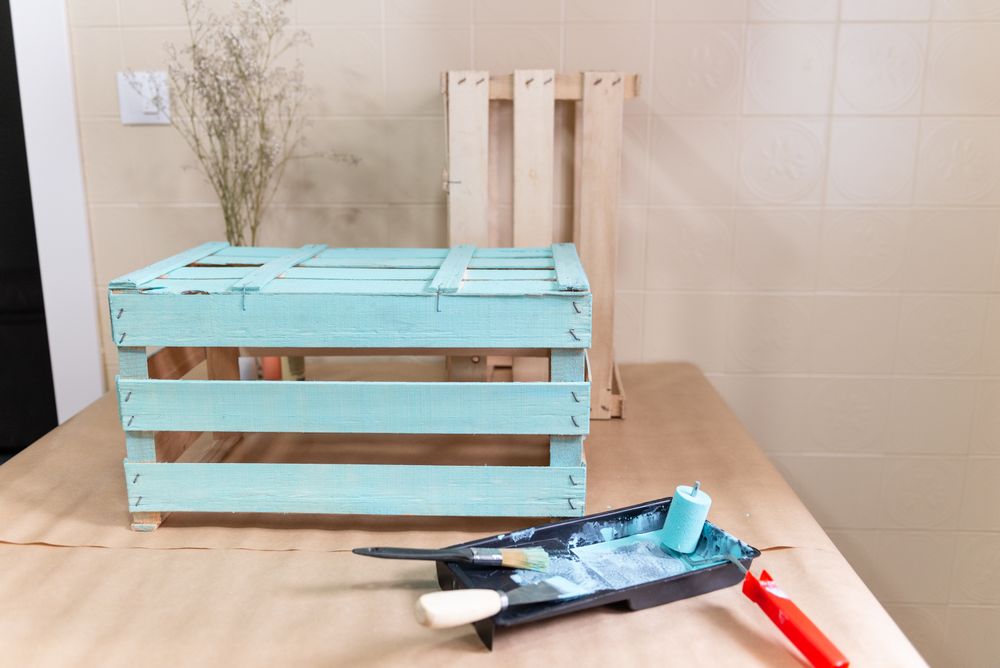 Freshly painted wooden box and paint tray on table