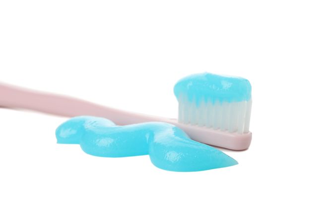 Toothbrush with toothpaste isolated on light background