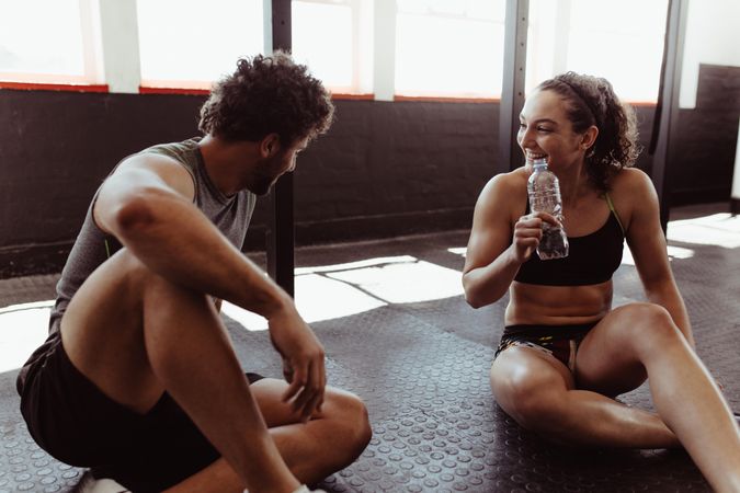 Couple taking a break after workout at gym