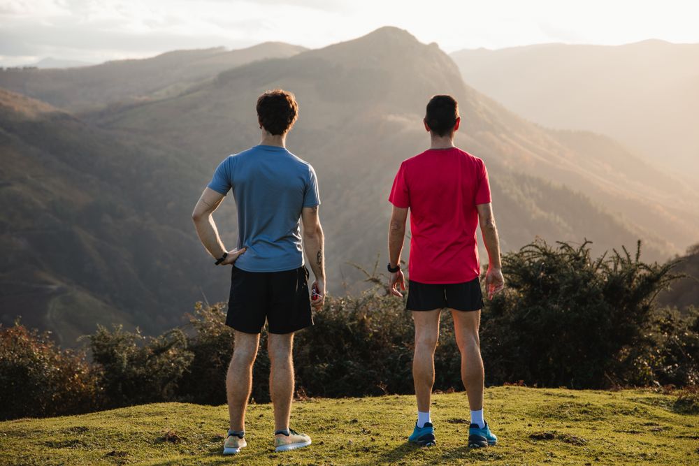 Male runners resting and enjoying mountain landscape