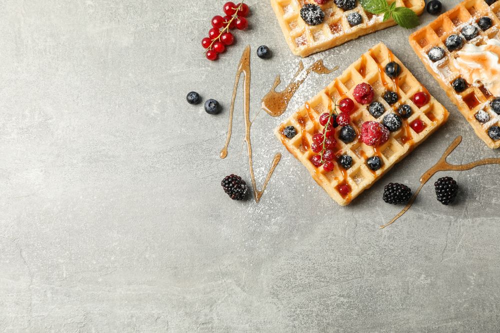Flat lay composition with sweet belgian waffles, space for text