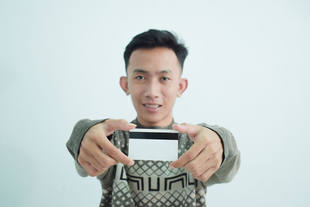 Asian young men wears sweater and holding blank credit card