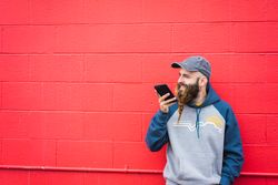 Man using smartphone near red wall