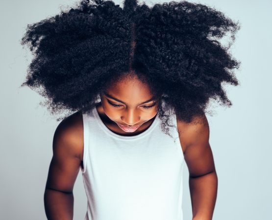 Studio portrait of serious girl with head down