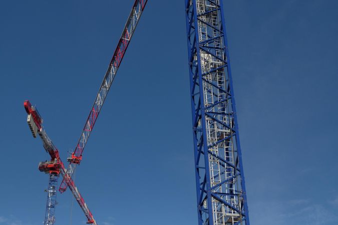 Red and blue cranes under blue sky