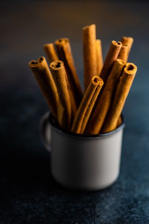 Side view of cinnamon sticks in container