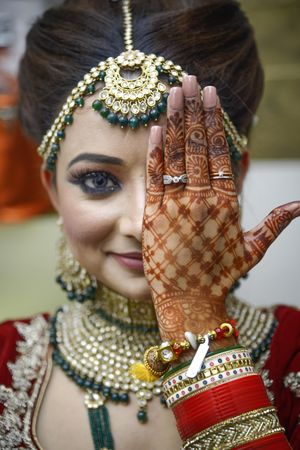 Indian bride covering her eye with henna hand