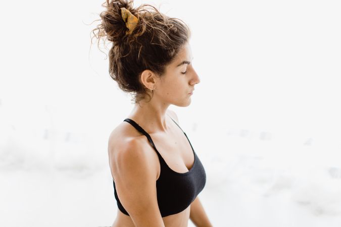 Sportive woman performing yoga pose in room