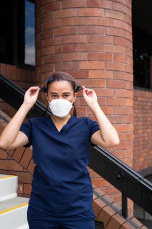 Nurse putting face shield down over face outside