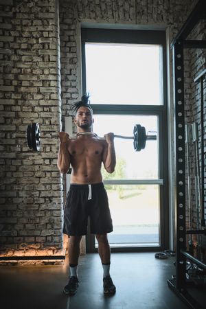 Black man exercising with barbell in gym