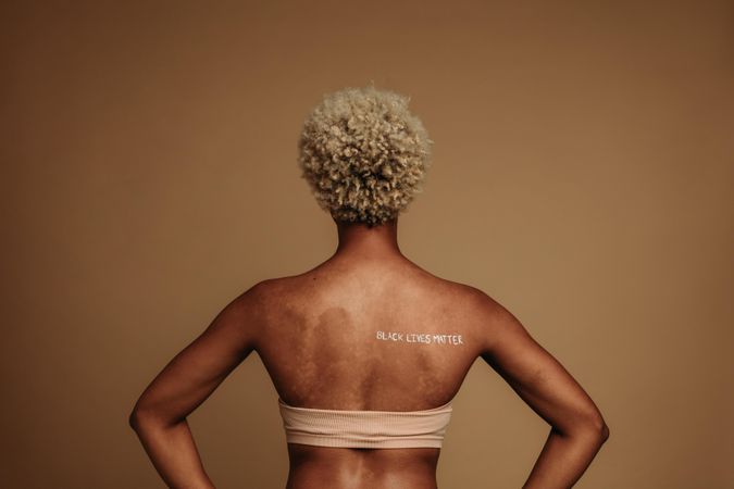 Rear view of woman standing with words Black lives matter written on back