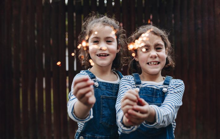 Two little girls holding sparkling hand fireworks