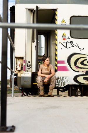 Military woman sitting near van
