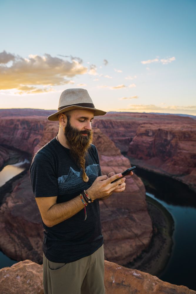 Traveler on the mobile phone near canyon