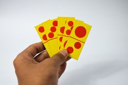 Hands holding five domino cards