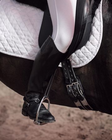 Boots of horseback rider in stirrups