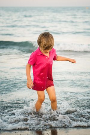 Playful boy splashing water on coast