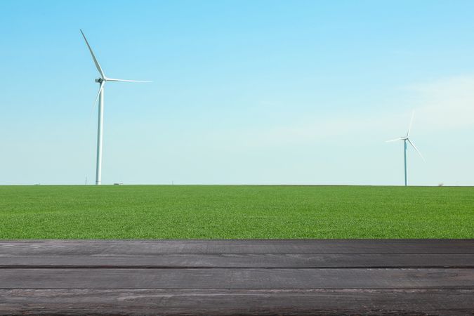 Wooden table against field with windmills. Agriculture concept. Mockup