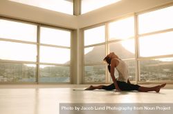 Woman doing a split on yoga mat 4262By
