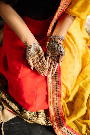 Top view of Indian woman in sari with mehndi tattoo on her hands