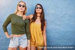 Two stylish female friends standing together and looking at camera 5rzwM5