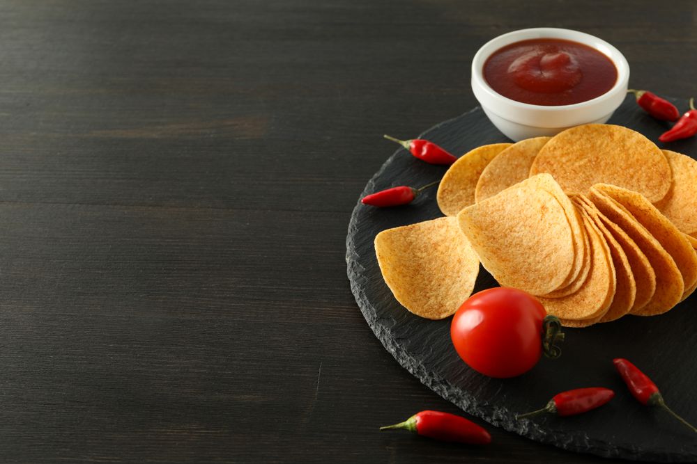 Potato chips in a bowl with chili pepper and sauce