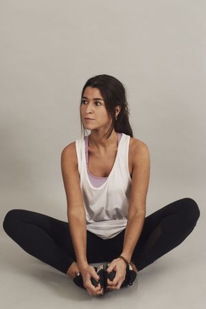Concentrated young active female athlete exercising in studio