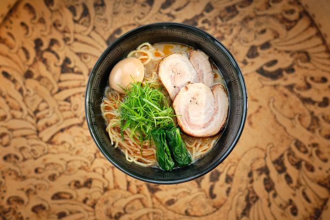 Bowl of traditional noddle dish with pork and nori in Asian restaurant