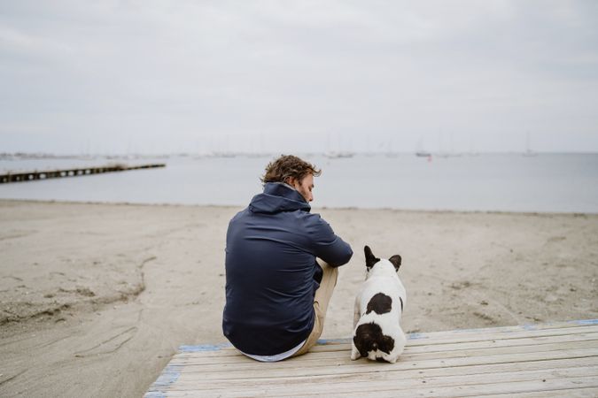 Man and dog resting on beach together