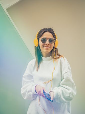 Trendy young woman with headphones and smartphone