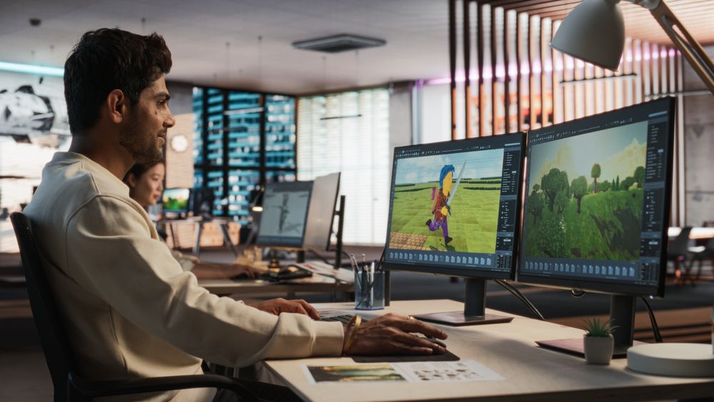Indian Male Game Designer Using Desktop Computer With 3D modelling Software To Design Characters And World For Immersive Adventure Video Game.