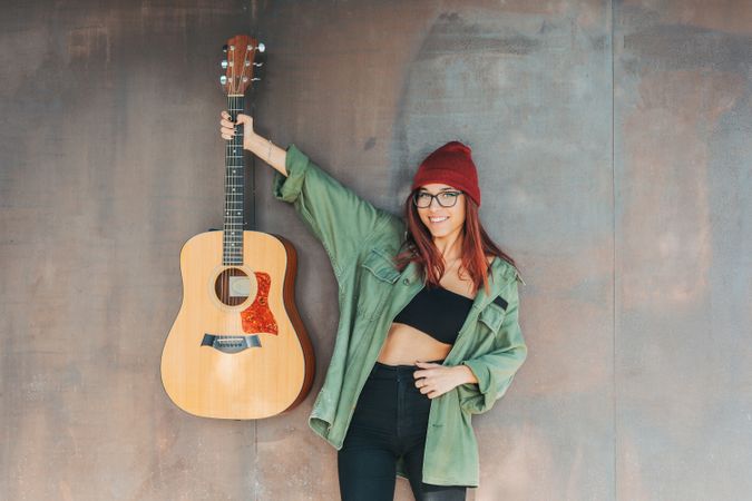 Woman in glasses leaning on wall