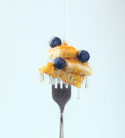 Appetizing fruit dessert with honey on fork