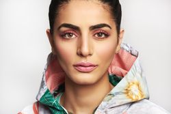 Beautiful woman pictured in colorful printed floral hoodie with bright background