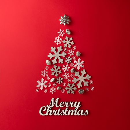 Christmas Tree made of snowflakes on red background with “Merry Christmas”